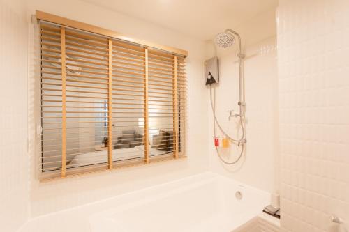 a bathroom with a tub and a window at Hotel PAPA Bangkok in Bangkok