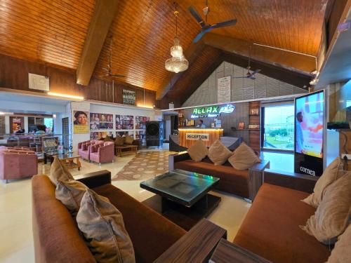 a large living room with couches and a tv at Relax Adventure Resort in Igatpuri