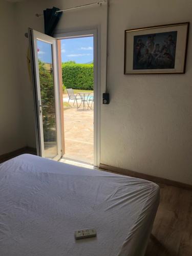 a bedroom with a bed and a sliding glass door at Les Cigales in La Crau