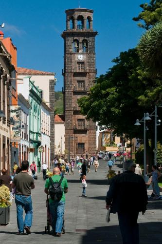 a group of people walking down a street with a clock tower at Anchieta 60 in La Laguna