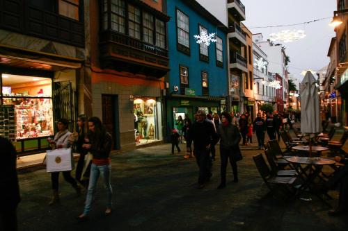 a group of people walking down a street at night at Anchieta 60 in La Laguna