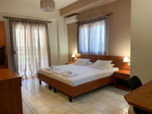 a bedroom with a large bed with white sheets at Hotel Aki in Loutra Edipsou