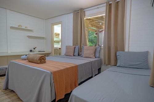 a bedroom with two beds with a hat on them at Pousada Vila Sossego in Lençóis