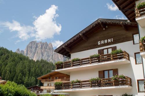 a hotel with a mountain in the background at Hotel Garnì Rosengarten in Pera
