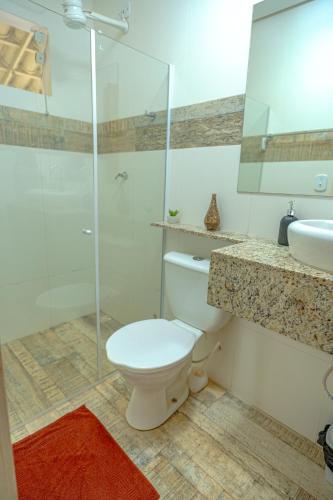 a bathroom with a toilet and a shower and a sink at Pousada Vila Sossego in Lençóis