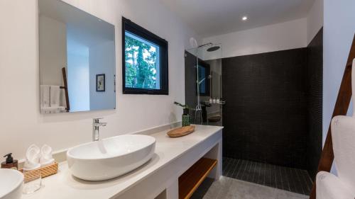 un bagno con lavandino e doccia di Villa Thansamaay by Elite Havens a Laem Sor