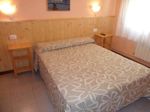 1 dormitorio pequeño con 1 cama y 2 mesas en Hostal Alce, en Nigrán