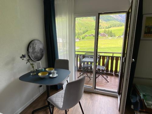 a room with a table and chairs and a balcony at Apartment 401 in Bergün