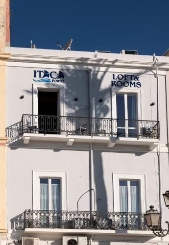 a white building with balconies on the side of it at Itaca Porto Loft& Rooms in Milazzo
