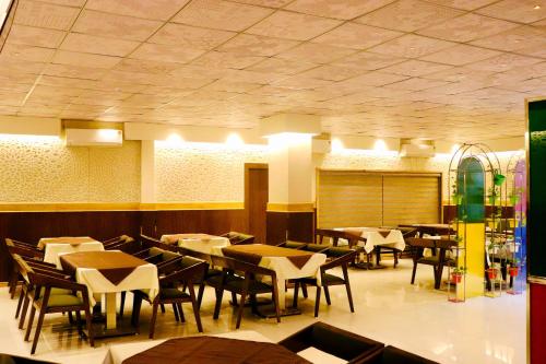 a dining room with tables and chairs in it at THE CLAN HOTEL - VIJAY NAGAR Indore in Indore