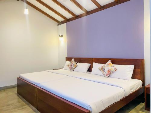 a bedroom with a bed with white sheets and pillows at PEKOE VALLEY Huluganga in Huluganga