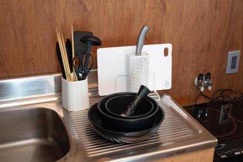 a kitchen counter with a sink and utensils at Ekichika TABI-NE in Kanazawa