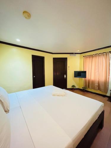 a bedroom with a large white bed in a room at Sheridan Villas Boracay in Boracay