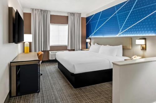 a hotel room with a bed and a desk at Comfort Suites Clackamas in Clackamas