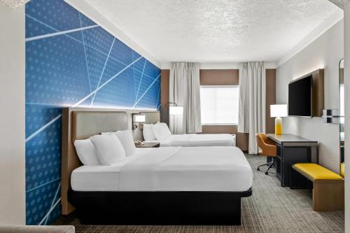 a hotel room with two beds and a desk at Comfort Suites Clackamas in Clackamas
