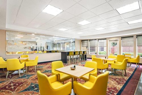 a waiting room with tables and yellow chairs at Comfort Suites Clackamas in Clackamas