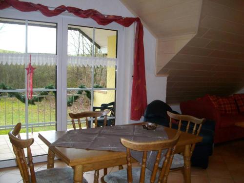 ein Esszimmer mit einem Tisch, Stühlen und einem Fenster in der Unterkunft Ferienwohnung Mastiaux in Mirbach