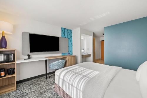 a hotel room with a bed and a flat screen tv at Sleep Inn & Suites Verona - Madison Southwest in Verona