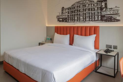 a bedroom with a large bed with an orange headboard at Lakefront Hotel by Brijwasi in Mathura
