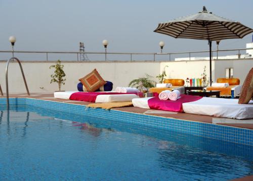 una fila de camas sentadas junto a una piscina en The Oasis, en Vadodara