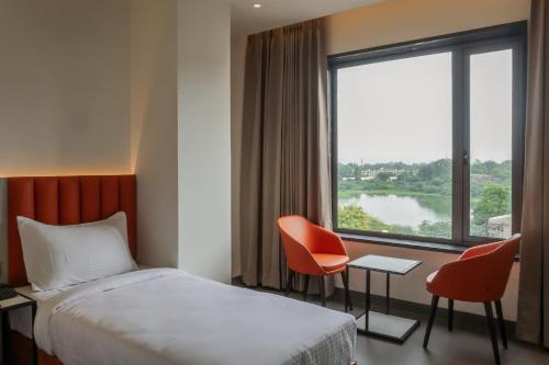 a hotel room with a bed and a large window at Lakefront Hotel by Brijwasi in Mathura