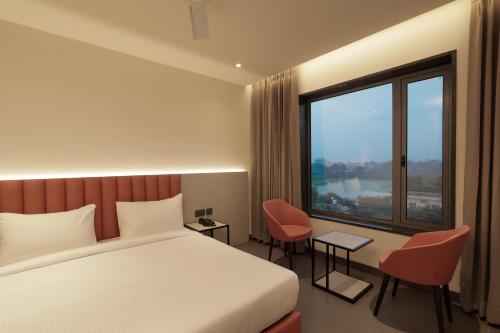 a hotel room with a bed and a large window at Lakefront Hotel by Brijwasi in Mathura