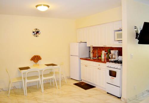 a kitchen with a table and a white refrigerator at Ocean Drive Villas in Hollywood