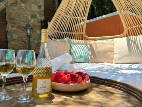 a bottle of wine and two glasses on a table at THE HOUSE ROSH PINA - 3BRM WITH POOl in Rosh Pinna