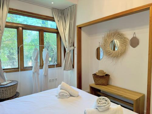 a bedroom with a white bed and a window at THE HOUSE ROSH PINA - 3BRM WITH POOl in Rosh Pinna
