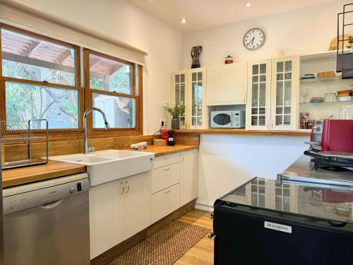 a kitchen with a sink and a clock on the wall at THE HOUSE ROSH PINA - 3BRM WITH POOl in Rosh Pinna