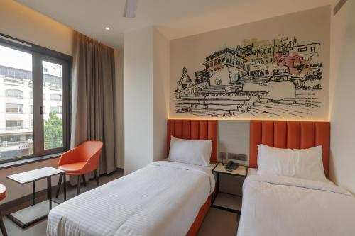 a hotel room with two beds and a drawing on the wall at Lakefront Hotel by Brijwasi in Mathura