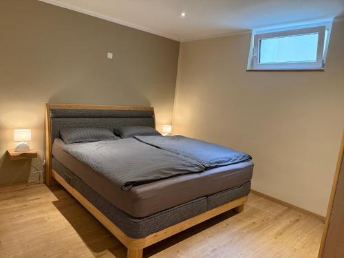 a bedroom with a bed in a room with a window at FEWO Flajs in Zweibrücken