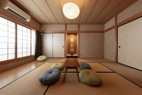 a room with a table and pillows on the floor at Ekichika TABI-NE in Kanazawa