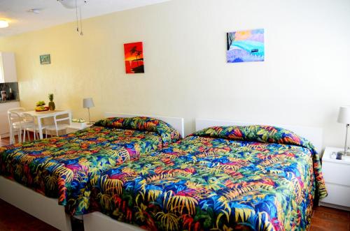 a bedroom with a bed with a colorful comforter at Ocean Drive Villas in Hollywood