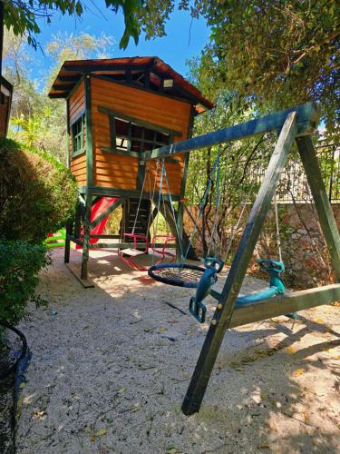 a playground with a play house and a swing at הבית בראש פינה - The House in Rosh Pinna