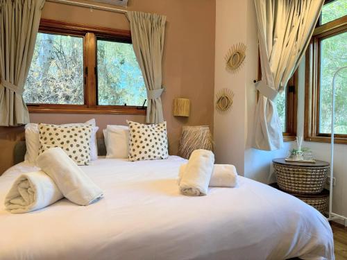 a bedroom with a large white bed with pillows at הבית בראש פינה - The House in Rosh Pinna