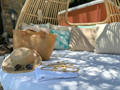 a hat and sunglasses sitting on top of a bed at הבית בראש פינה - The House in Rosh Pinna