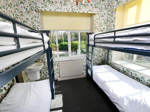 two bunk beds in a room with a window at YHA Windermere in Troutbeck