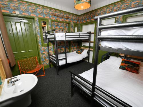 a room with three bunk beds and a sink at YHA Windermere in Troutbeck