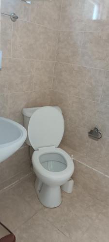 a bathroom with a white toilet and a sink at LouNik stay hotel and rooms in K'obulet'i