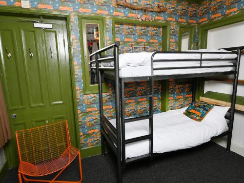 a room with three bunk beds and a chair at YHA Windermere in Troutbeck
