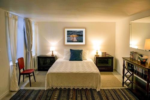 - une chambre avec un lit, deux tables et deux lampes dans l'établissement Appartement de Sophie, à Sète