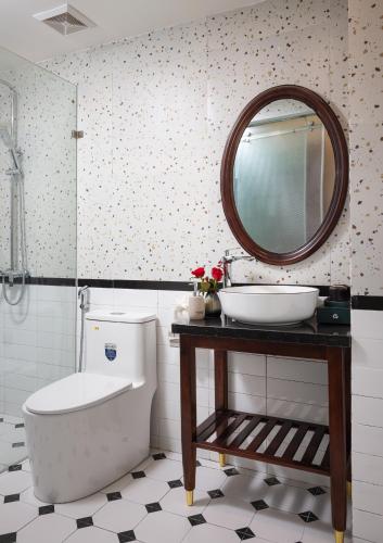 a bathroom with a sink and a toilet and a mirror at Tam Coc Sueno Hotel in Ninh Binh