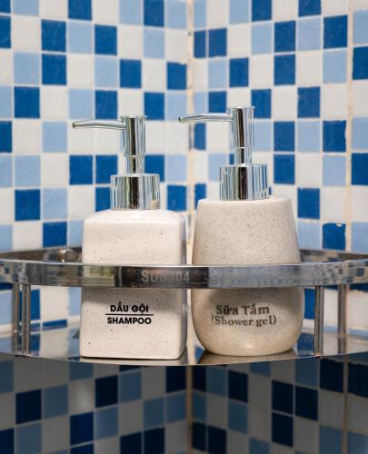 three white toothbrushes on a shelf in a bathroom at Tam Coc Sueno Hotel in Ninh Binh