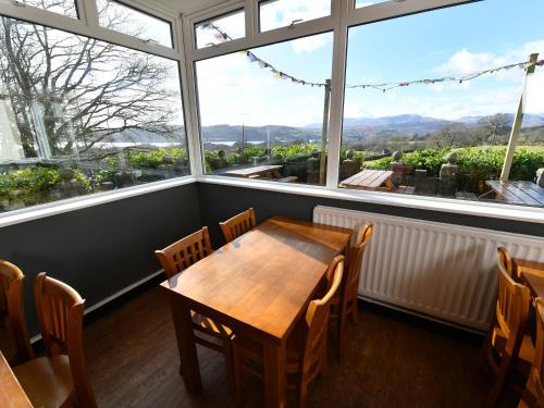 a table and chairs in a room with a large window at YHA Windermere in Troutbeck