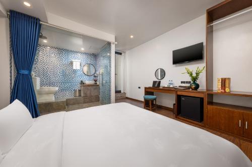 a bedroom with a large white bed and a bathroom at Tam Coc Sueno Hotel in Ninh Binh