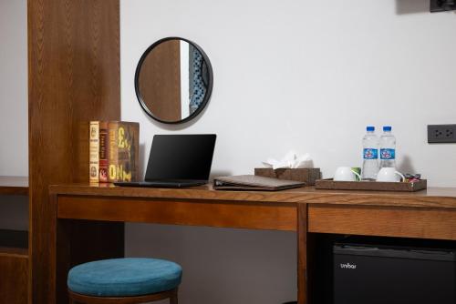 a wooden desk with a laptop and a mirror at Tam Coc Sueno Hotel in Ninh Binh