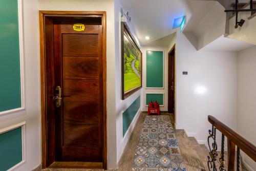 a hallway with a wooden door and a staircase at Tam Coc Sueno Hotel in Ninh Binh