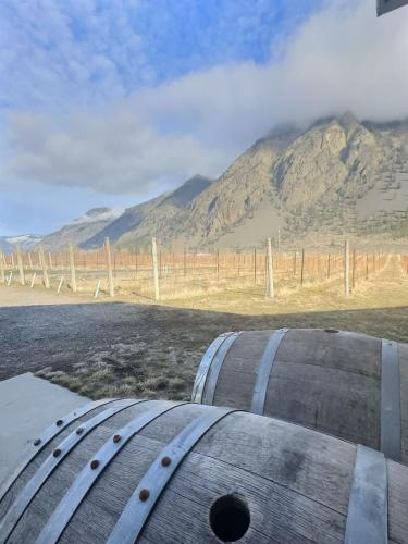 a barrel sitting on the side of a road with a mountain at Vineyard Home Casa De Herrera in Keremeos