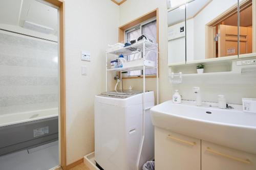 東京にあるUU Houseの小さなバスルーム(シンク、白い冷蔵庫付)